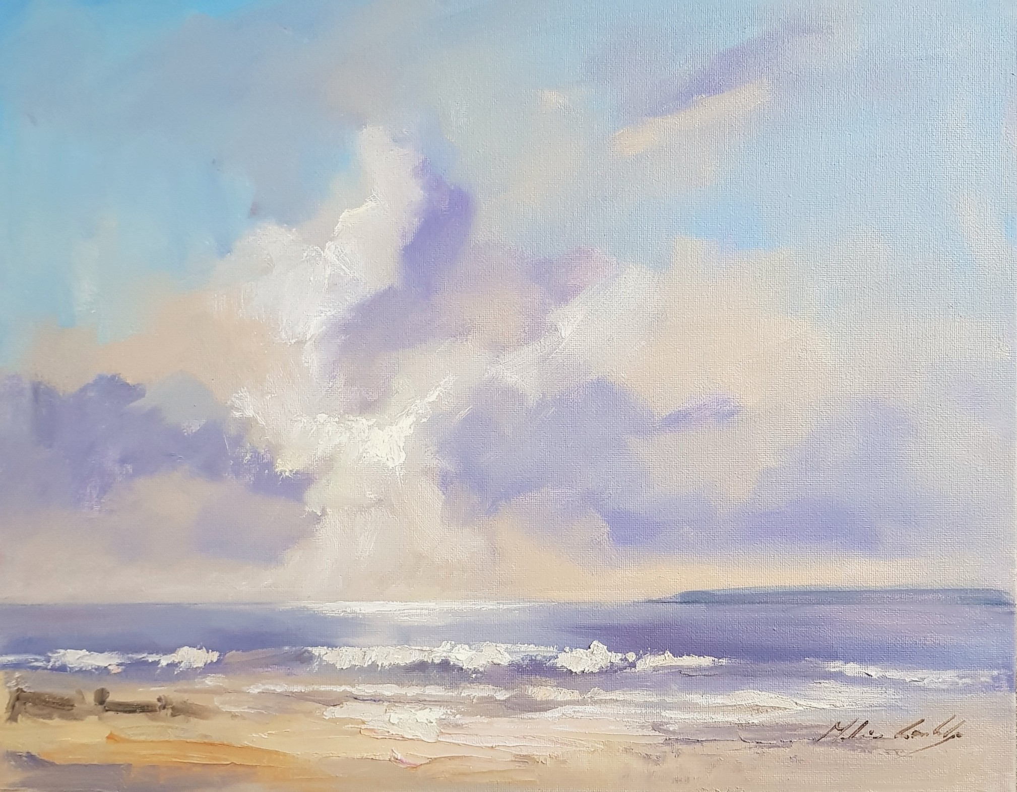 Sunlight breaking through the clouds onto the sea and beach at East Wittering